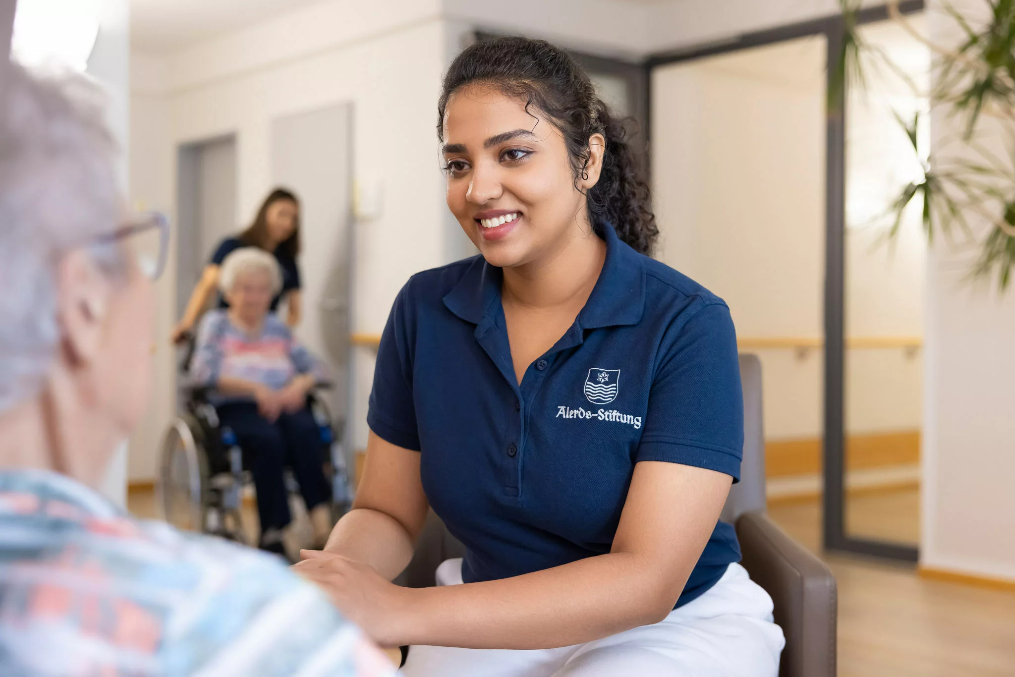 Arbeiten Sie in einer visionären Stiftung mit Tradition Pflegekraft hält die Hand einer Seniorin